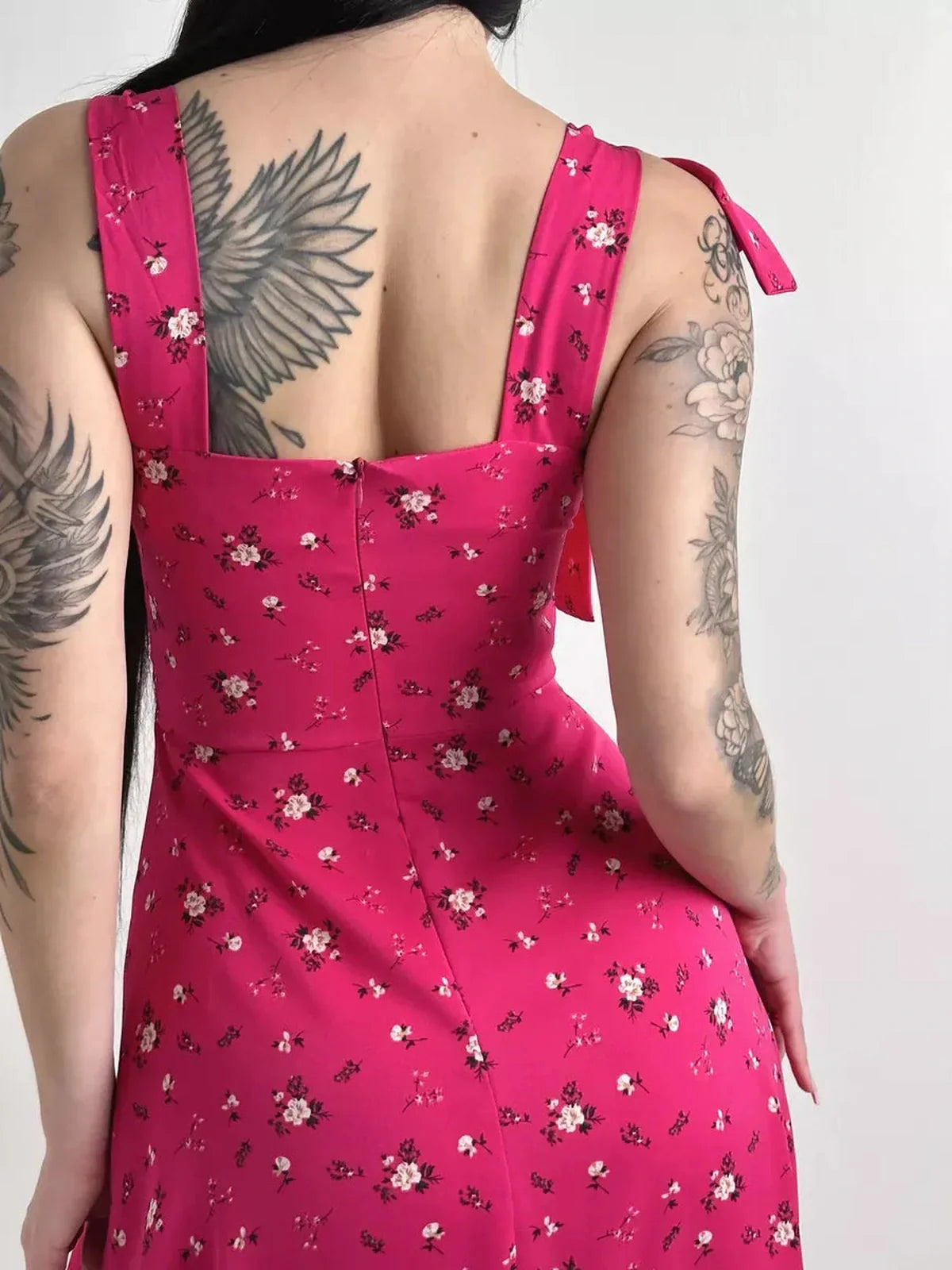 Back view of the Rosé Charm Midi Dress showcasing its floral print and adjustable shoulder tie detail.