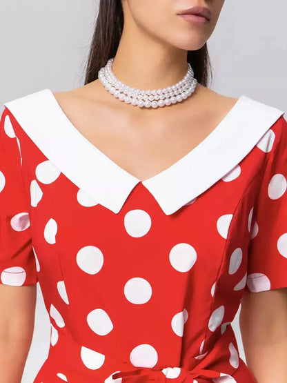 Close-up of the Retro Charm Midi Dress featuring red polka dots, a white collar, and a stylish tie belt for vintage elegance.