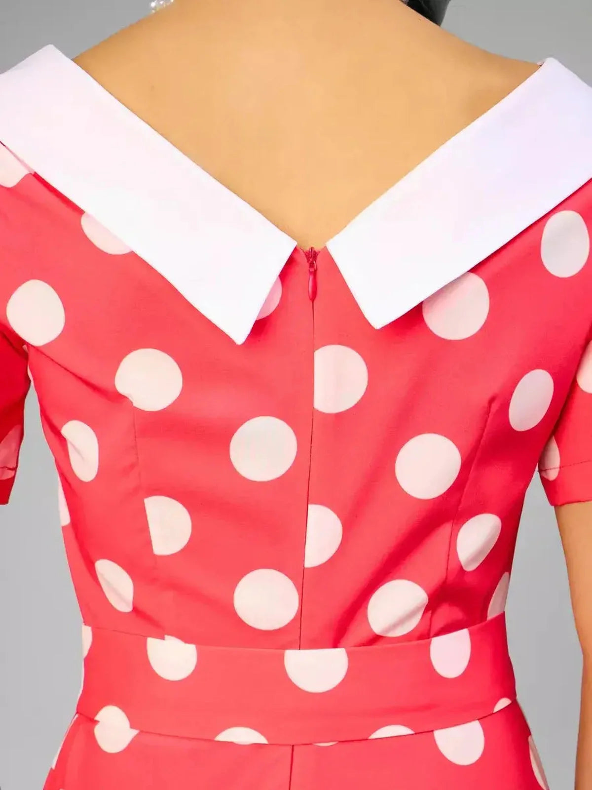 Back view of the Sailor Chic Midi Dress featuring a white sailor collar and pink polka dot pattern.