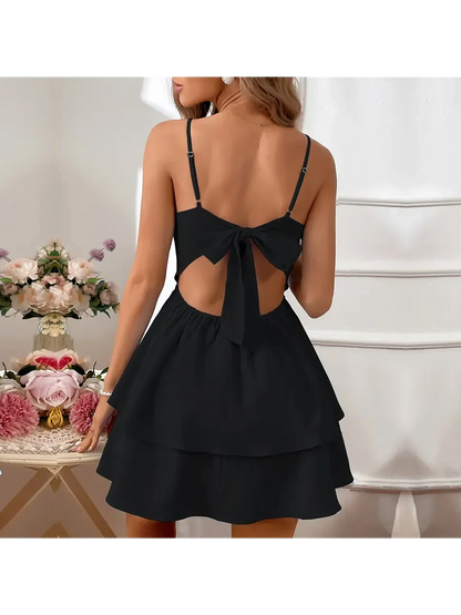 Back view of a flirty black tiered mini dress with a bow tie detail, perfect for summer celebrations.
