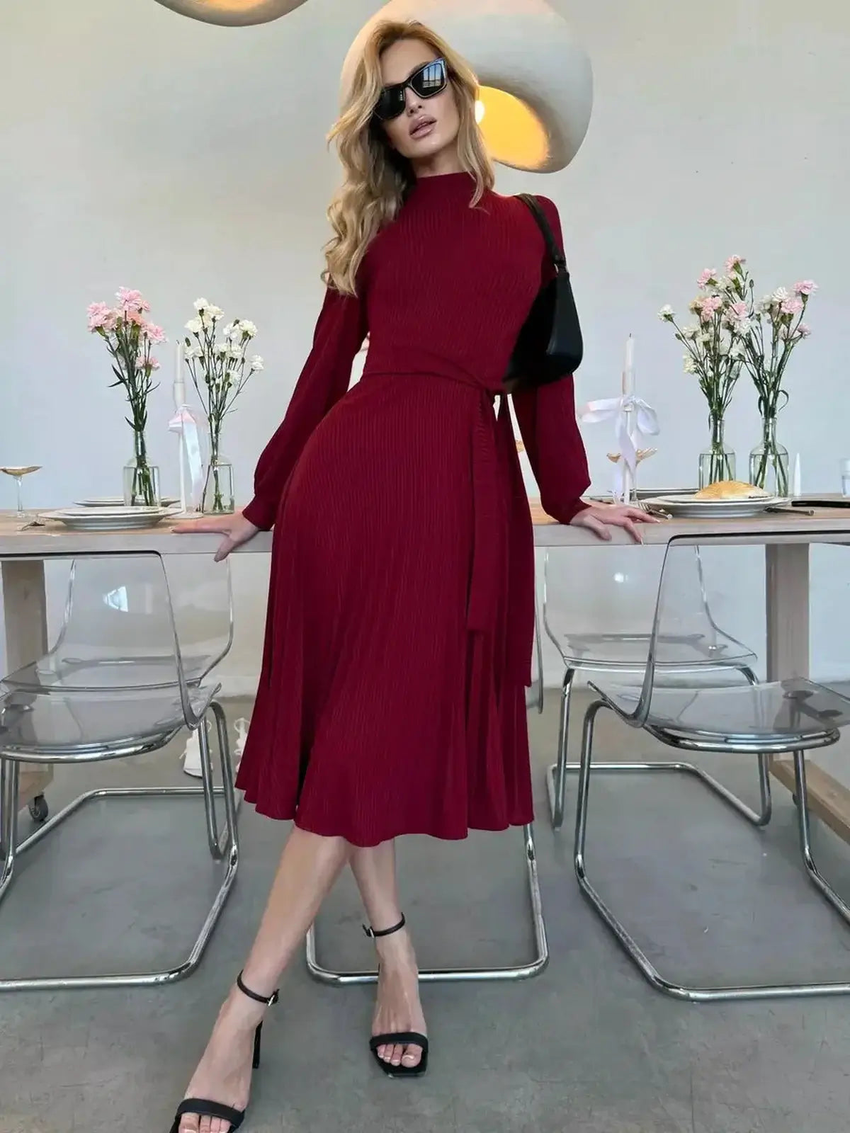 Model wearing a Crimson Grace Midi Dress, featuring pleats and a form-fitting design for formal occasions.