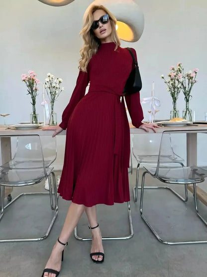 Model wearing a Crimson Grace Midi Dress, featuring pleats and a form-fitting design for formal occasions.