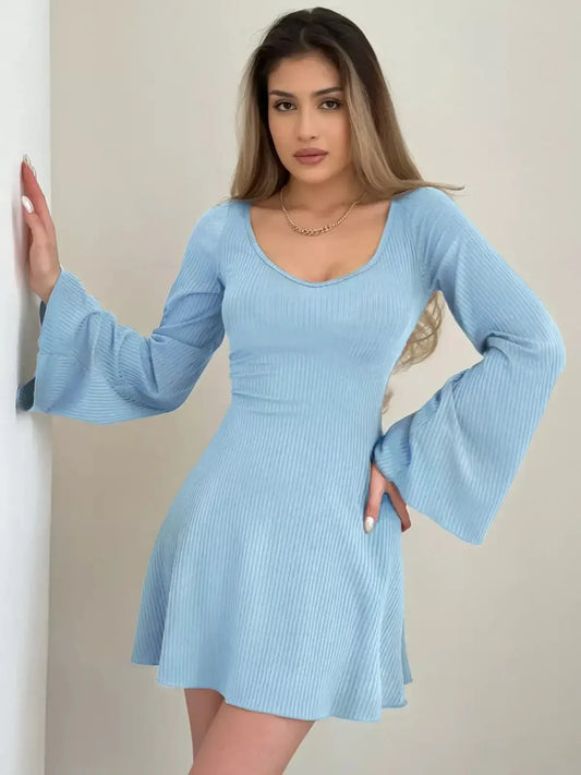 Woman wearing a light blue Sky Flare Mini Dress with flared sleeves, perfect for summer or formal occasions.