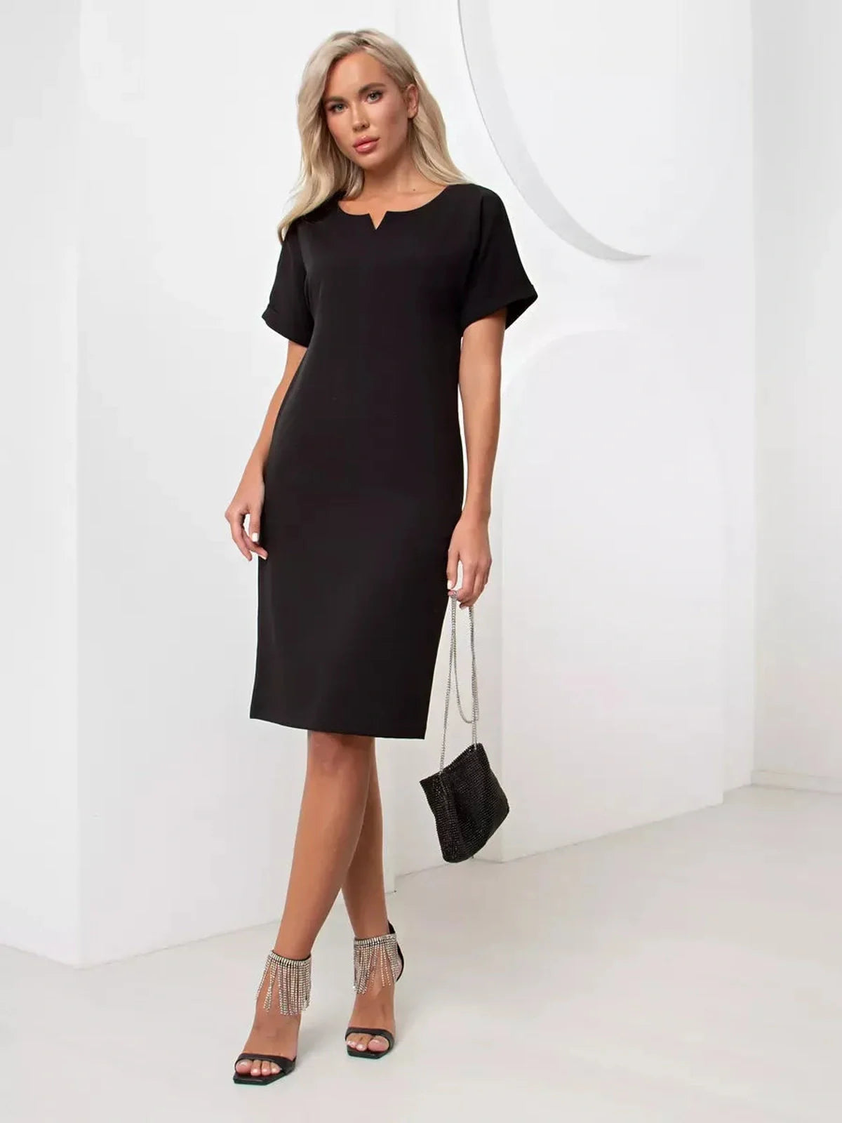 Modern Grace black mini dress featuring short cuffed sleeves and a relaxed silhouette, perfect for formal or casual occasions.