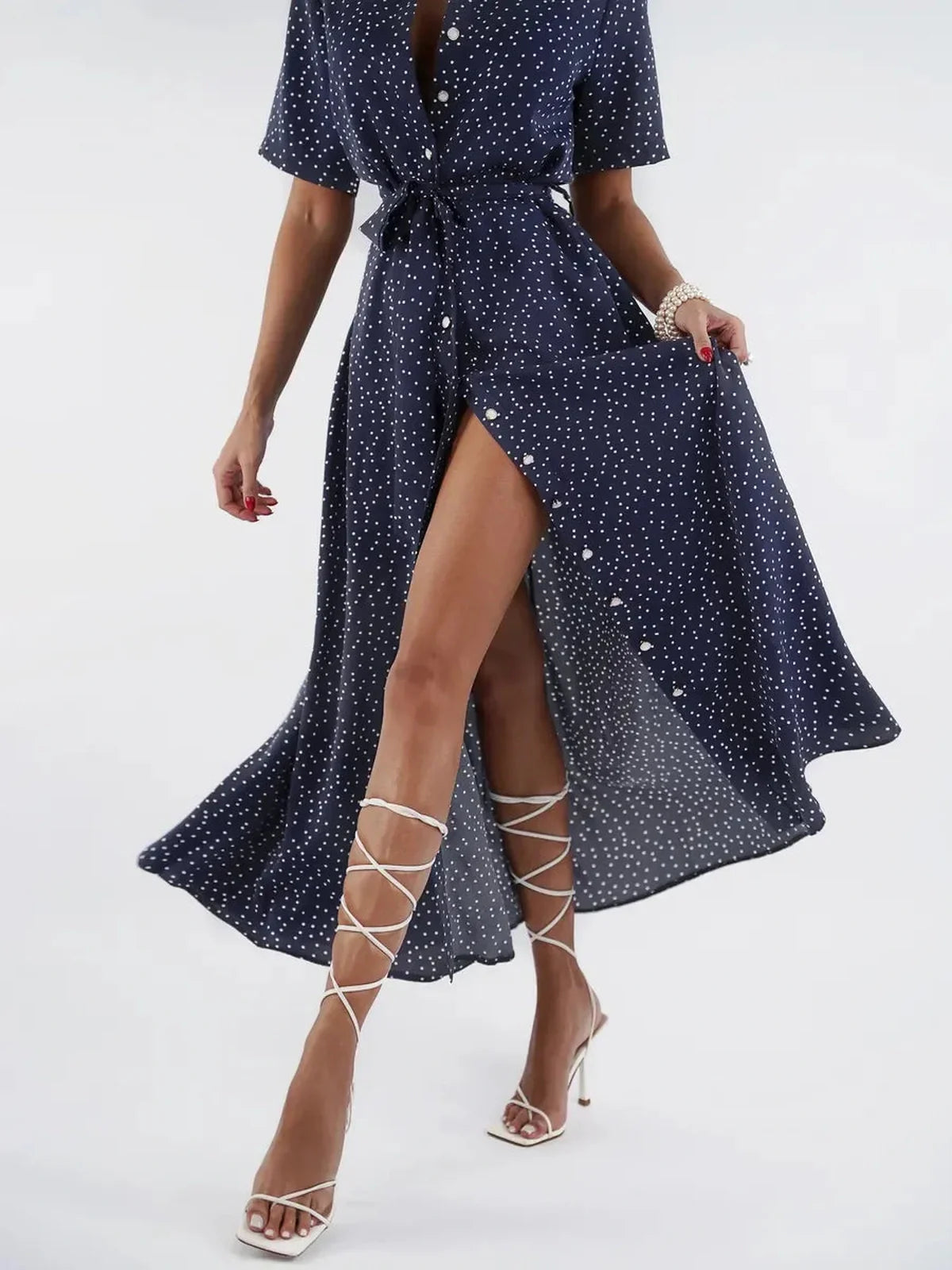Model wearing a Midnight Dot Midi Dress with navy base and white polka dots, showcasing its elegant flow and button-down front.