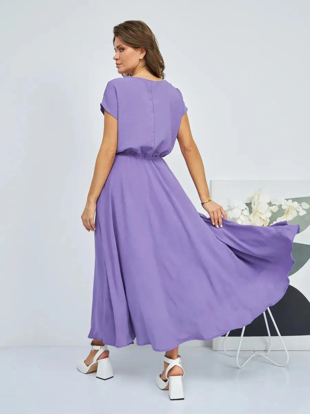 Model wearing a lavender maxi dress with lightweight fabric, showing elegant flow and gathered waist, ideal for summer occasions.
