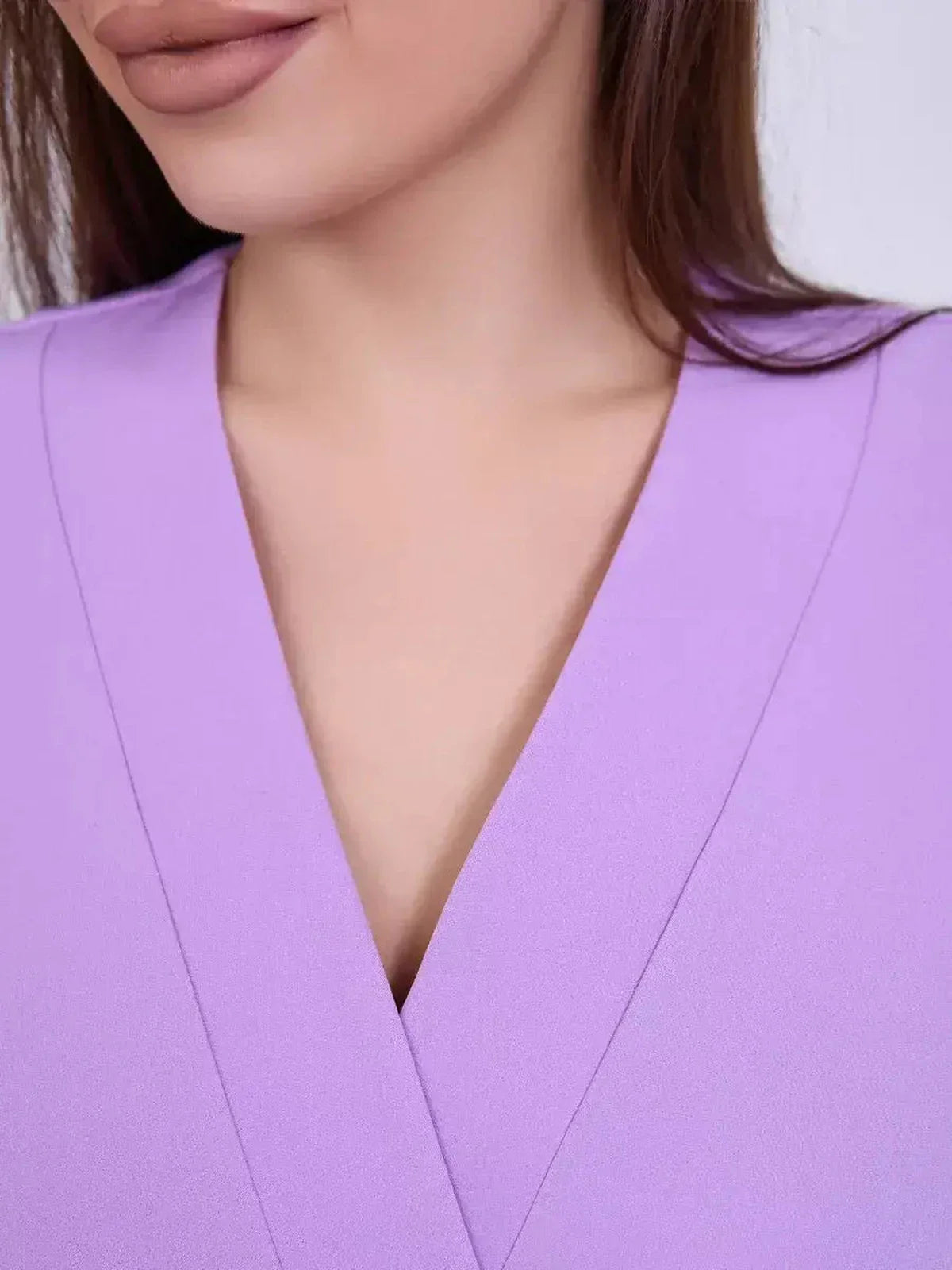 Close-up of a woman in a lilac dress showcasing a flattering V-neckline, perfect for weddings and formal events.