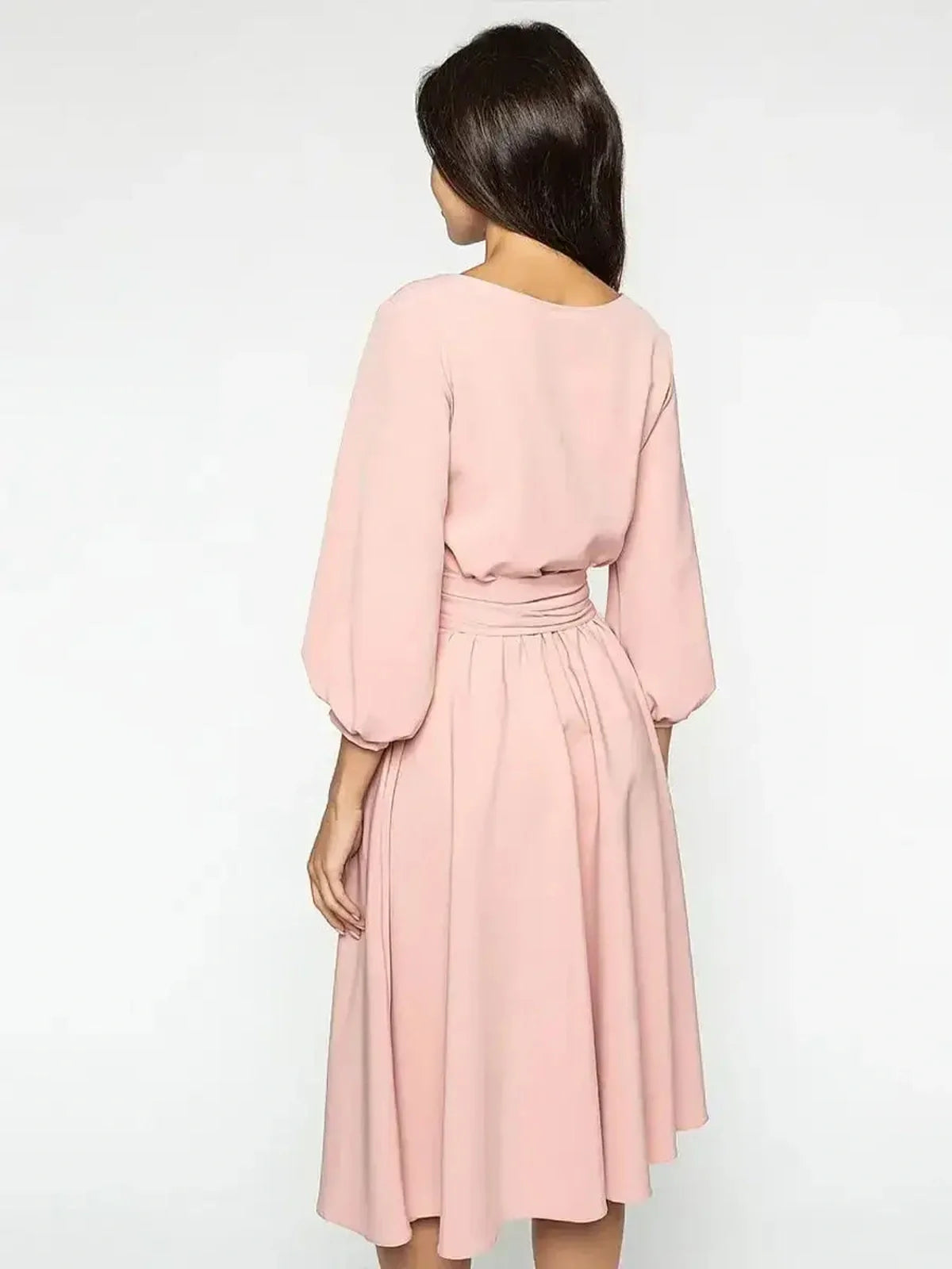 Back view of the Blush Whisper Midi Dress showcasing puff sleeves and a flowing skirt in a soft pink tone.