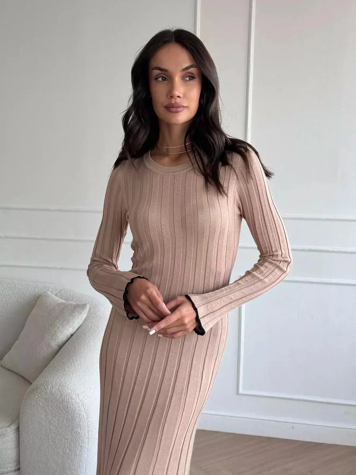 Woman in Sahara Curve Maxi Dress with ribbed texture, showcasing an elegant, soft beige silhouette.