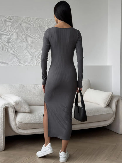 Back view of a woman in a sleek gray midi dress showcasing a thigh-high slit and paired with white sneakers.