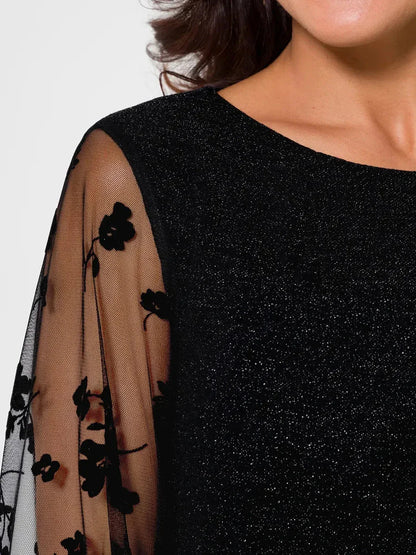 Close-up of Luxe Spark Midi Dress showcasing sheer floral sleeves and shimmering black fabric for elegant occasionwear.