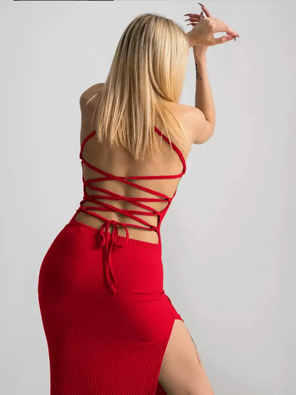 Woman in a red lace midi dress featuring a corset back and side slit, showcasing a striking silhouette.