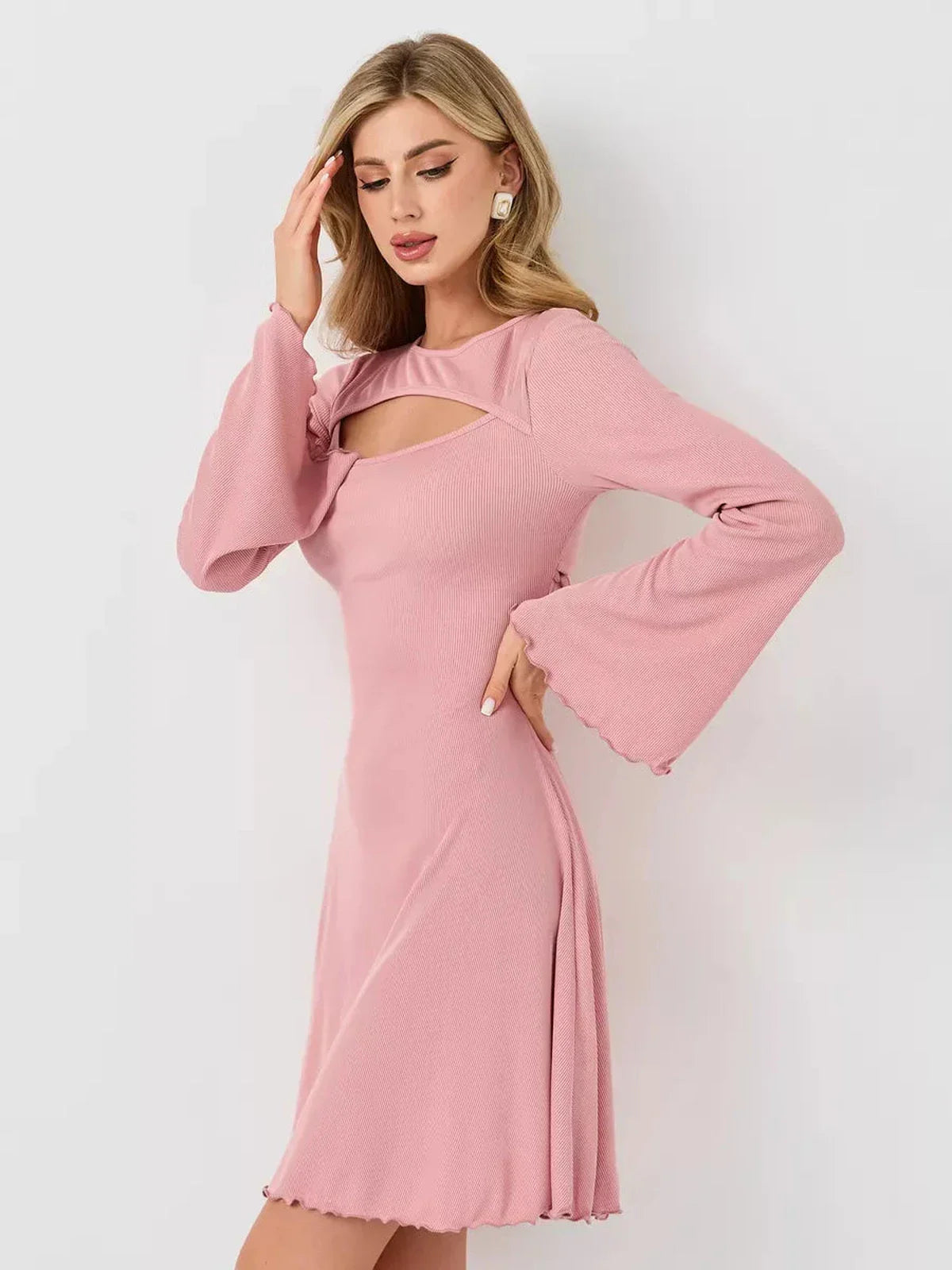 Model wearing a pink Blush Whisper dress featuring a U-neckline and flared sleeves, perfect for summer events.