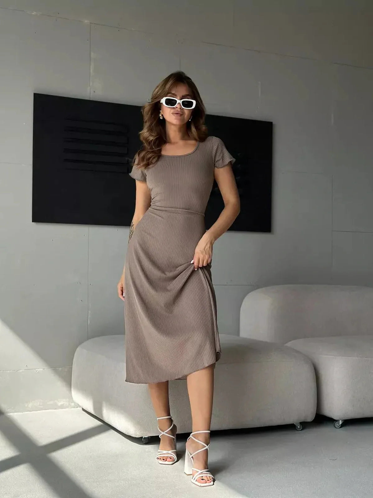 Stylish woman in a ribbed contour midi dress, showcasing an elegant silhouette, ideal for weddings and formal events.