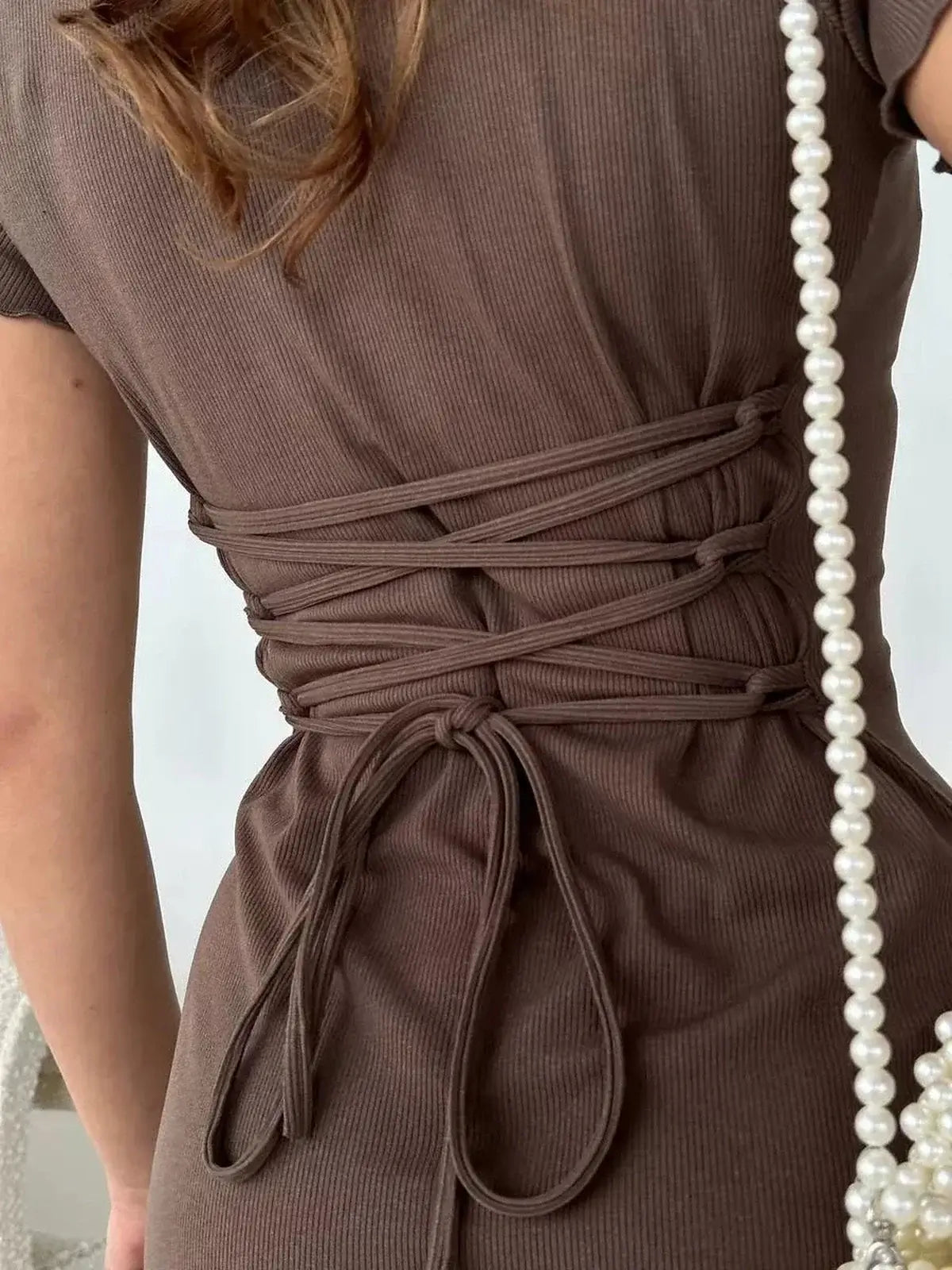 Close-up of the lace-up back detail on the Cocoa Cinch Mini Dress in rich chocolate tone, showcasing its flattering fit.