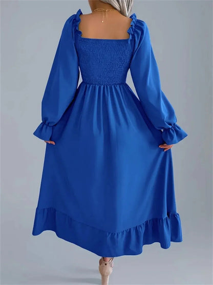 Serena Midi Dress in blue featuring a smocked bodice, long sleeves, and romantic ruffles, perfect for summer and formal events.
