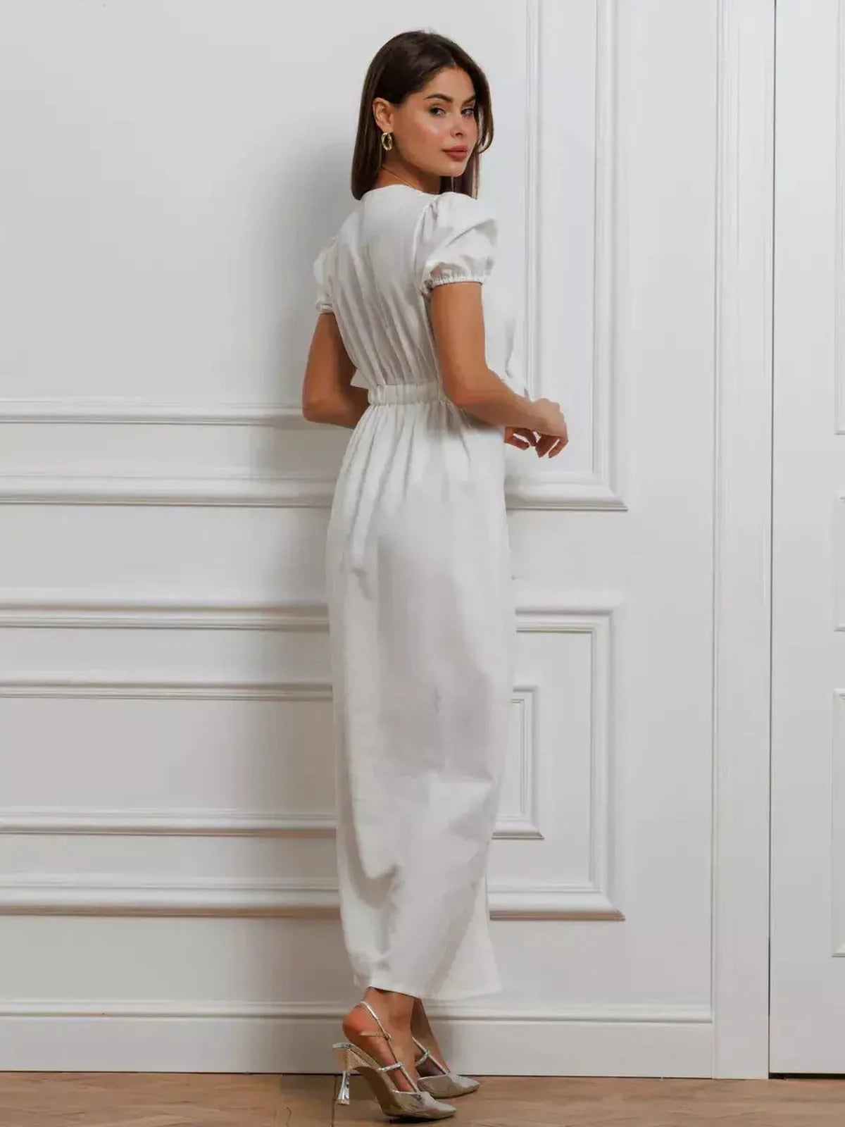 Back view of a woman in a white maxi dress with puff sleeves, perfect for summer weddings and formal events.