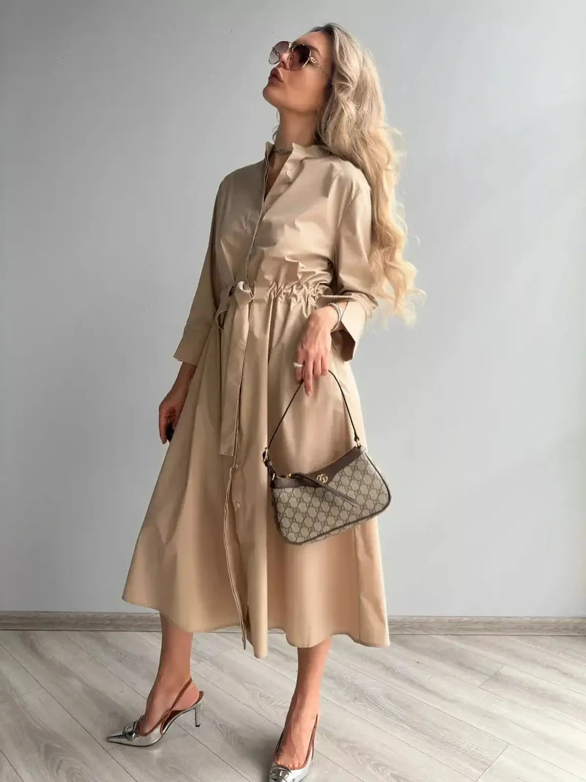 Elegant woman in a Studio Beige Midi Dress, paired with stylish accessories, perfect for weddings or formal occasions.