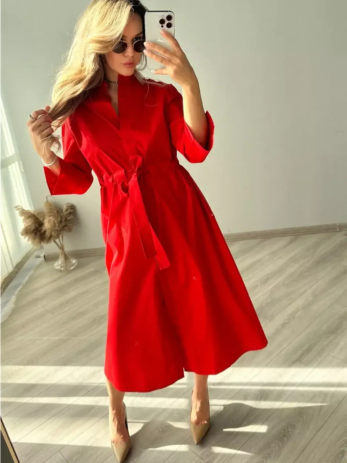 Model showcasing the Crimson Ease Midi Dress in vibrant red, with a belted waist and elegant flowing silhouette.