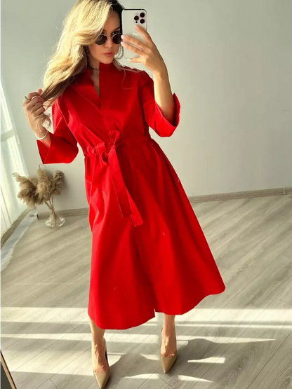 Model showcasing the Crimson Ease Midi Dress in vibrant red, with a belted waist and elegant flowing silhouette.