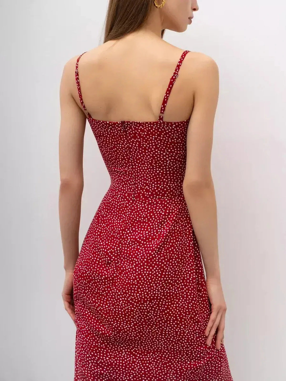 Back view of a Cherry Dots Midi Dress featuring a flattering wrap design and playful polka dot print on a red background.