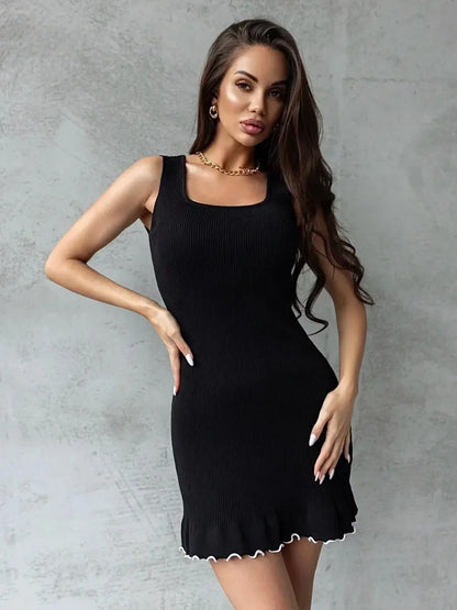 Stylish model showcasing a Ribbed Charm Mini Dress in black with a flouncy hem, perfect for cocktail or summer occasions.