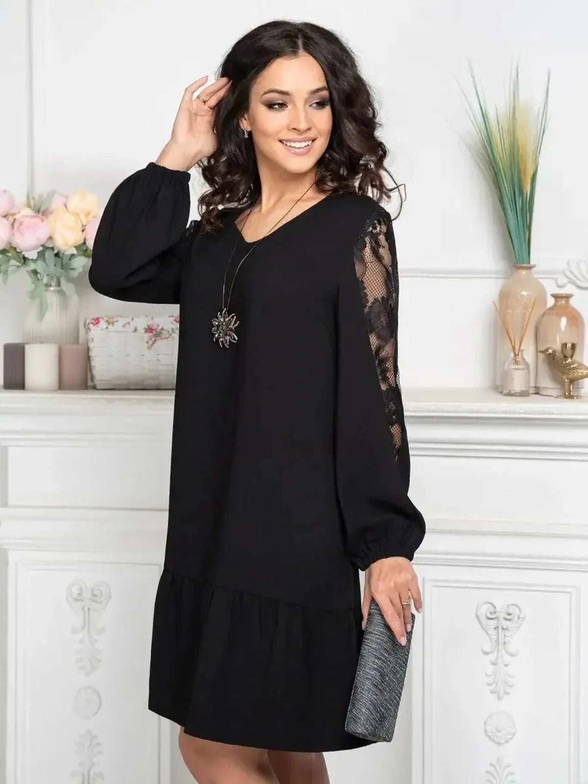 Elegant black dress with sheer lace sleeves, perfect for wedding guests or formal events.