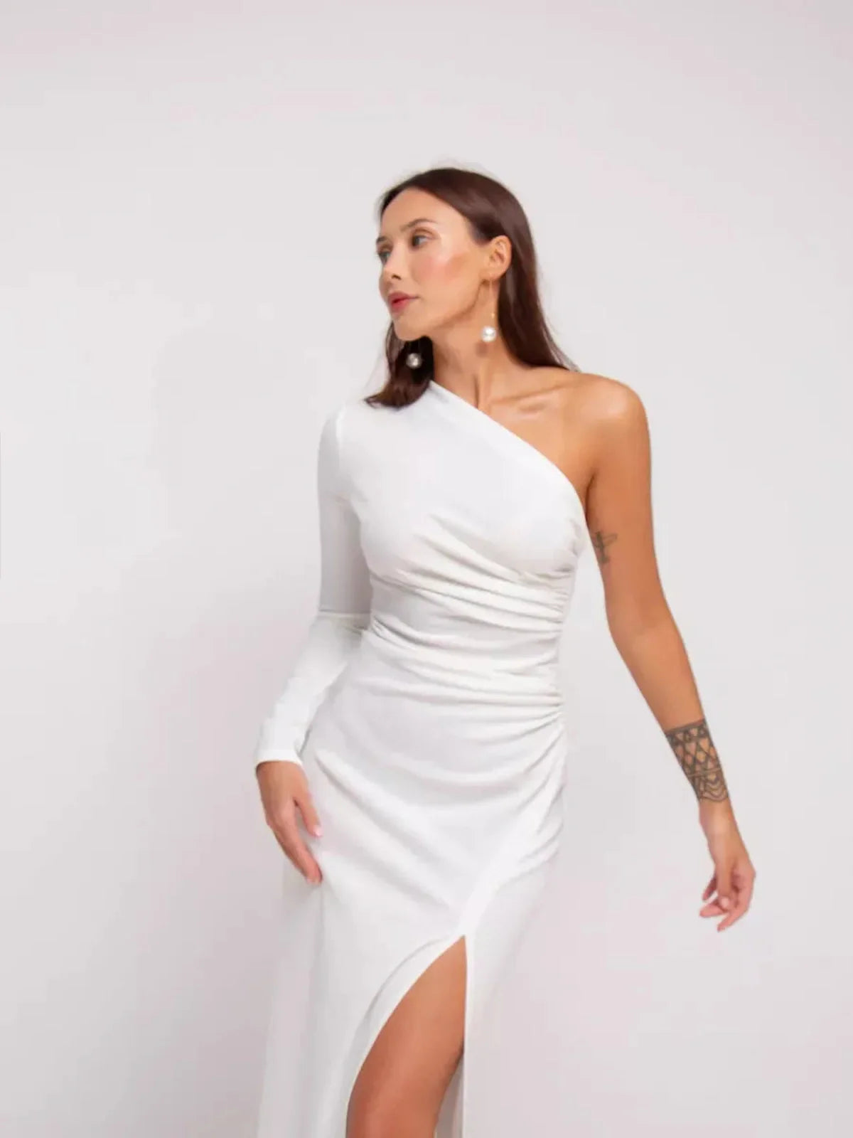 Elegant one-shoulder Celeste Maxi Dress in white with draped details and high side slit, perfect for formal occasions.