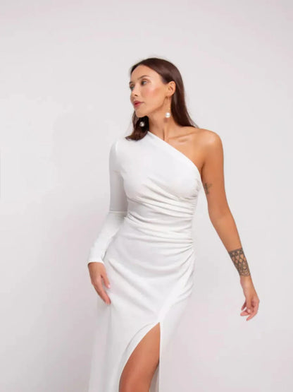 Elegant one-shoulder Celeste Maxi Dress in white with draped details and high side slit, perfect for formal occasions.