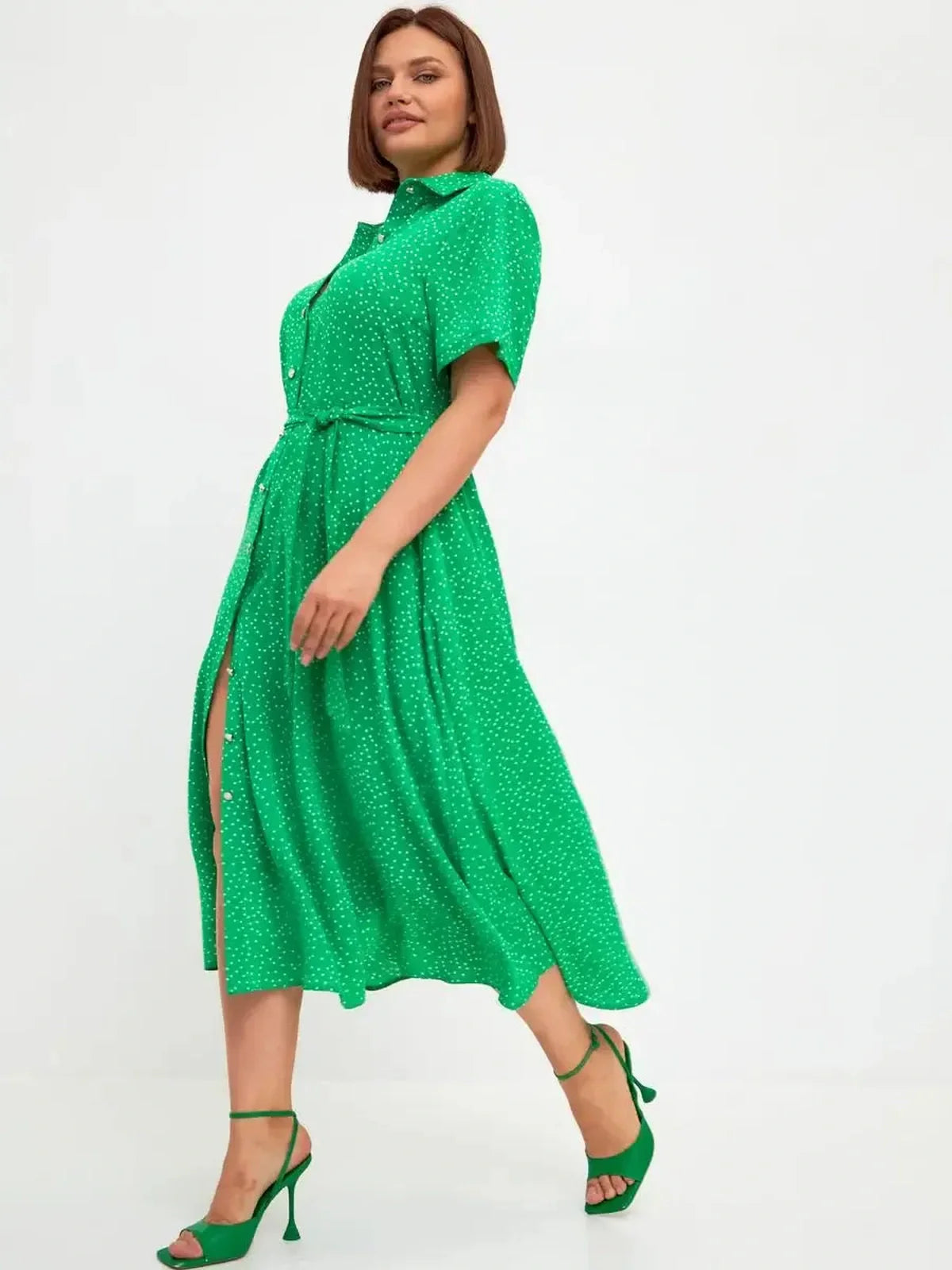 Model showcasing the Garden Dot Midi Dress in vibrant green with white dots, perfect for summer or wedding guest attire.