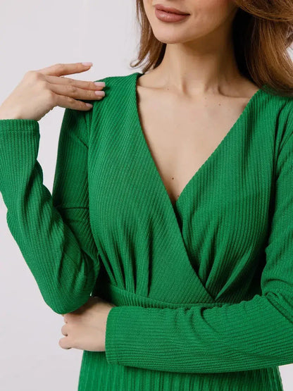 Model wearing an elegant Emerald Grace Midi Dress featuring a V-neckline and long sleeves in a vibrant green color.