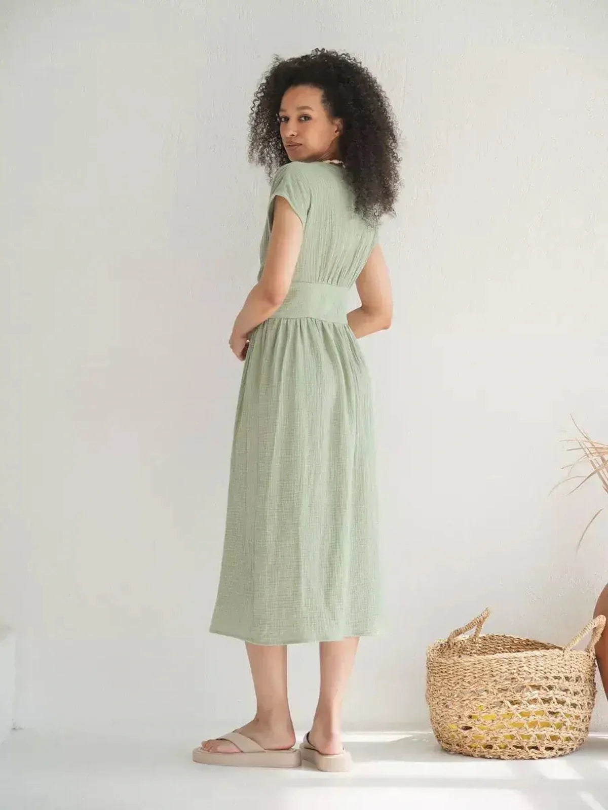 Model wearing a khaki Verdana Midi Dress featuring short sleeves and a flattering corset-inspired waist, perfect for summer occasions.