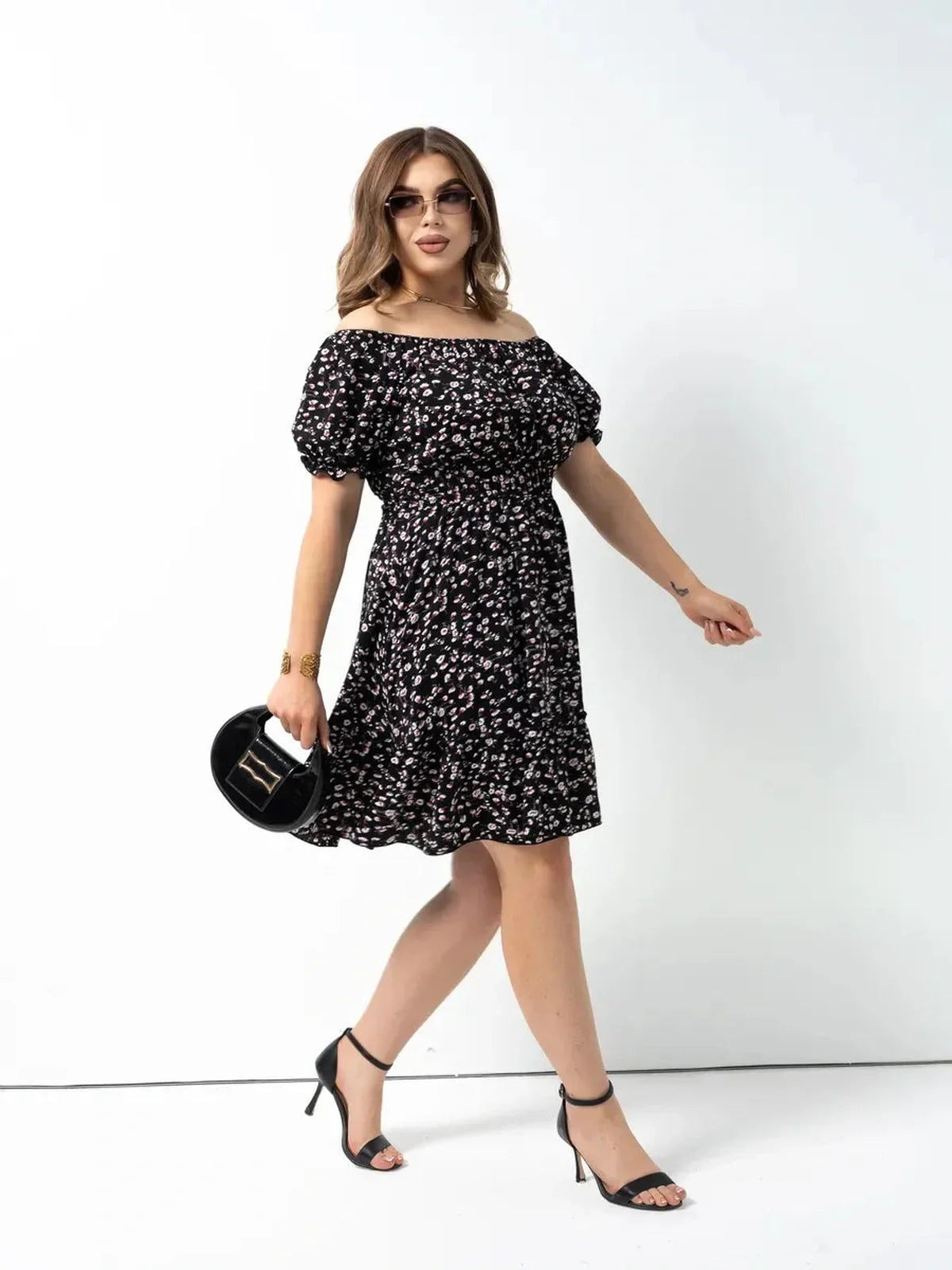 Stylish woman in an off-shoulder black floral dress, perfect for summer, weddings, or special events.