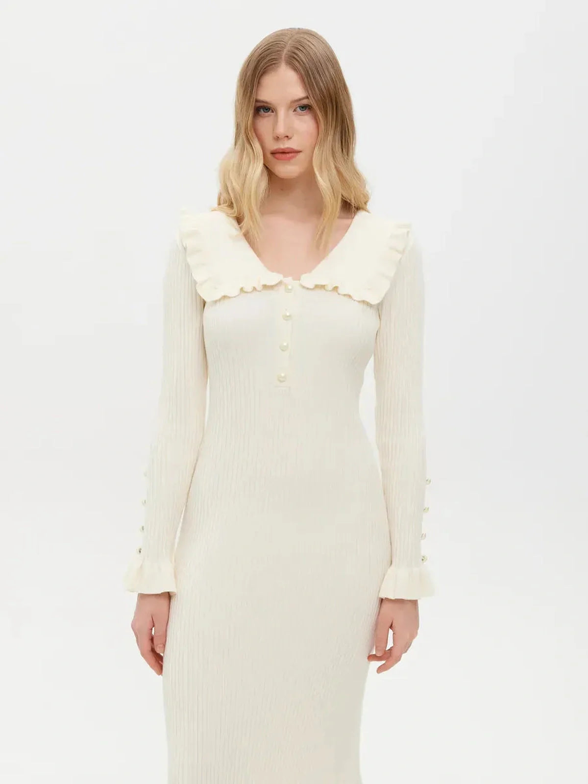 Model wearing a Pearl Ruffle Midi Dress with a flounce collar and pearl buttons, showcasing feminine elegance and sophistication.