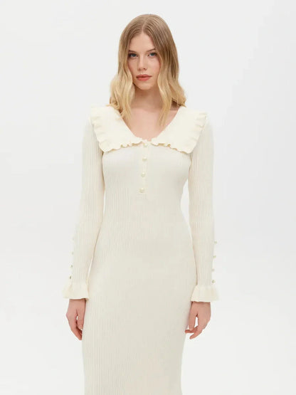 Model wearing a Pearl Ruffle Midi Dress with a flounce collar and pearl buttons, showcasing feminine elegance and sophistication.