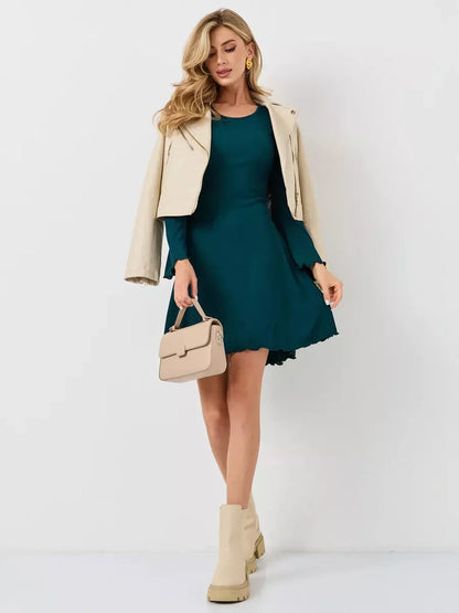 Model showcasing the Emerald Whisper mini dress in emerald green, styled for wedding guest or cocktail events.