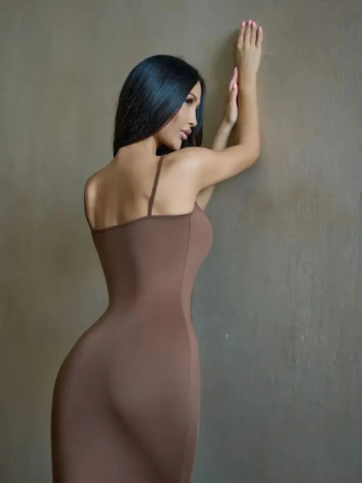 Model wearing Cocoa Curve Maxi Dress in warm chocolate hue, showcasing a fitted silhouette and minimalist design.
