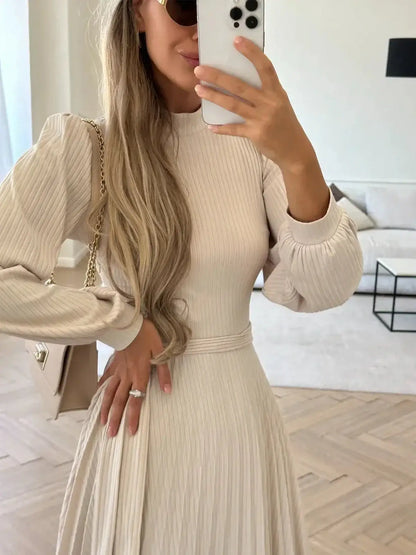 Model showcasing the Ivory Whisper Midi Dress with ribbed knit texture and pleated skirt, perfect for weddings and formal events.