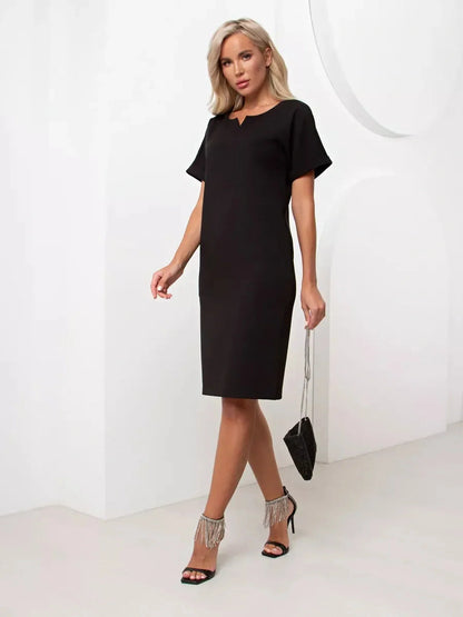 Model wearing the Modern Grace black mini dress with relaxed fit and short cuffed sleeves.
