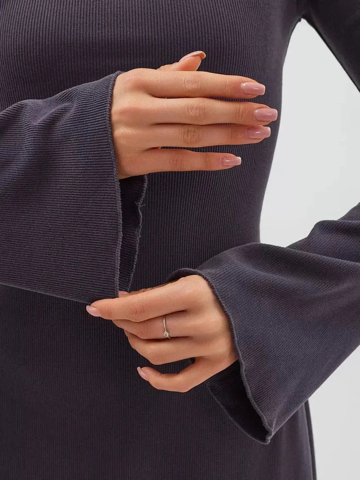 Close-up of flared sleeves on the Graphite Charm Mini Dress, showcasing the soft knit texture and elegant design.