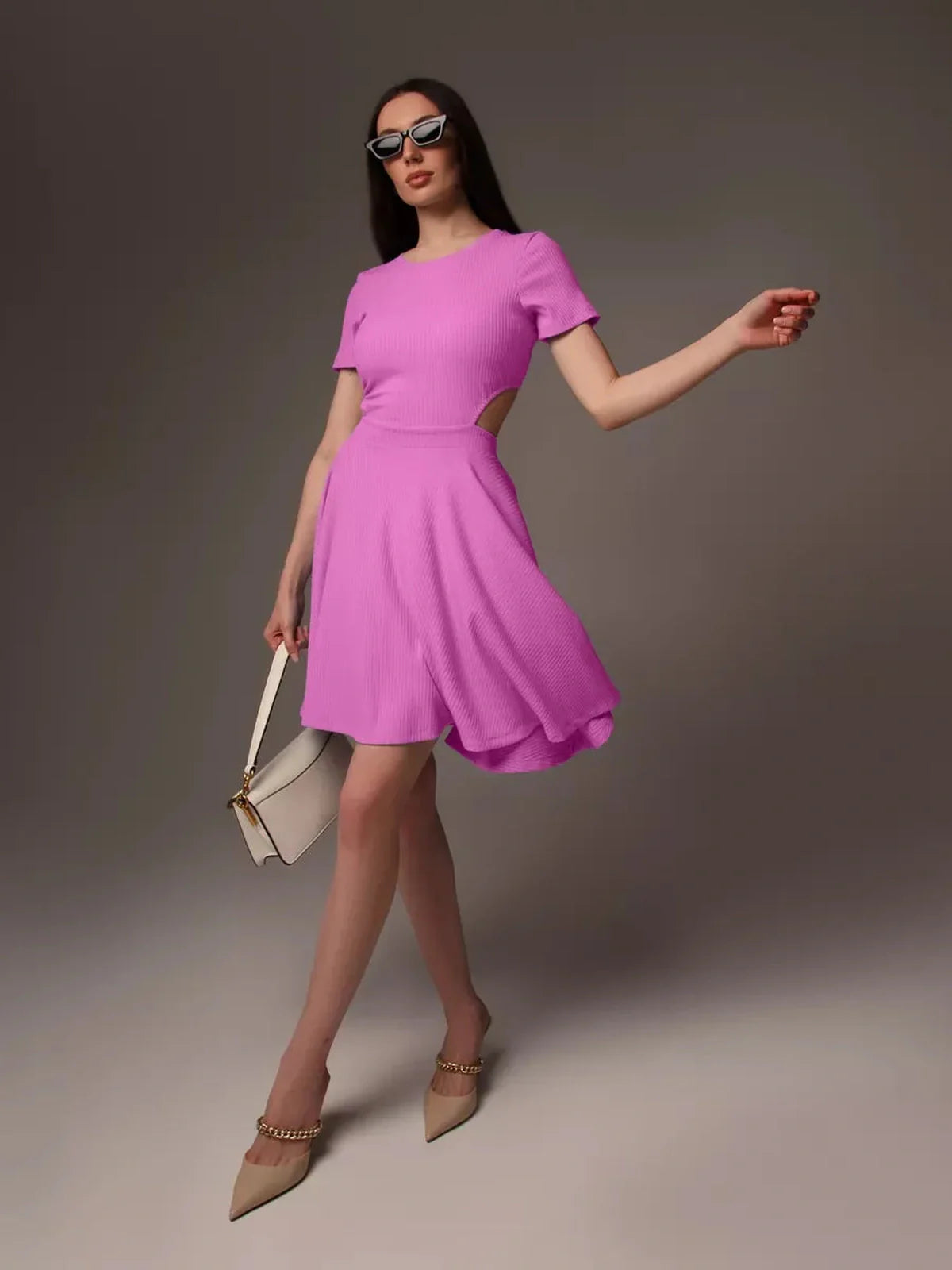 Model wearing a Cutout Charm Mini Dress in bright pink, showcasing a fit-and-flare silhouette and stylish open waist detail.