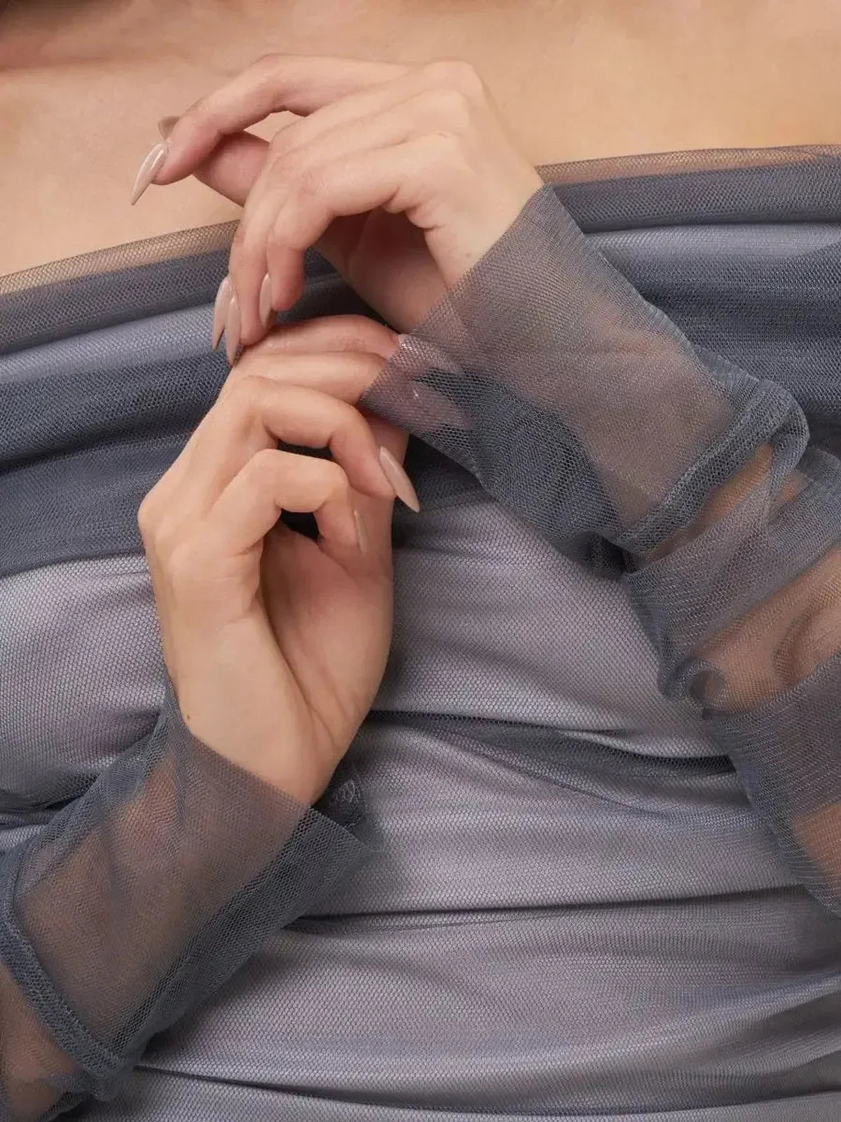 Elegant hands styled in sheer fabric, showcasing the delicate details of a Sculpted Sheer Midi Dress.