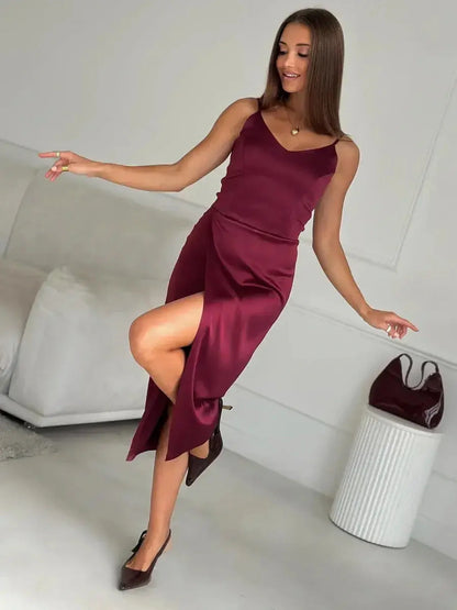 Woman wearing a burgundy satin midi dress with a side slit, perfect for weddings and formal occasions.