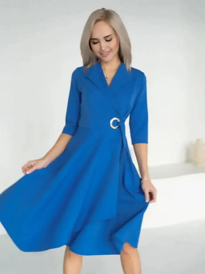 A model showcasing the Sapphire Flow Midi Dress in royal blue with a draped wrap design and stylish metallic waist detail.