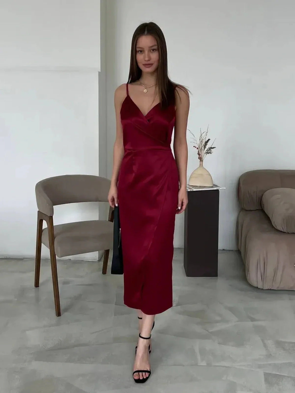 Elegant woman in garnet satin midi dress with wrap silhouette, perfect for summer weddings and formal events.
