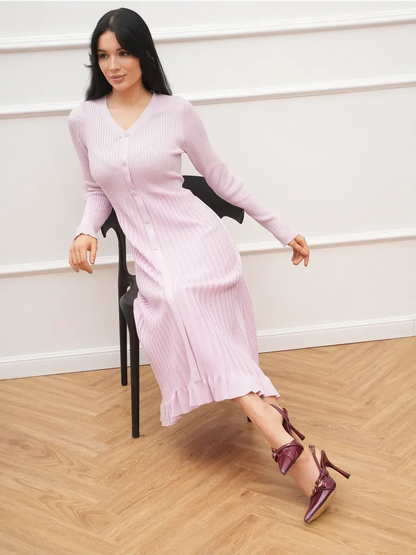 Woman in a pink Crystal Knit Midi Dress with ribbed texture, styled with elegant heels, showcasing a chic and sophisticated look.