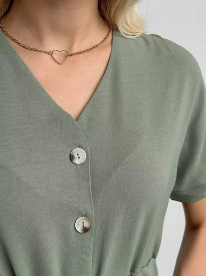 Close-up of a woman wearing a khaki Botany Midi Dress, featuring a V-neckline and decorative buttons.