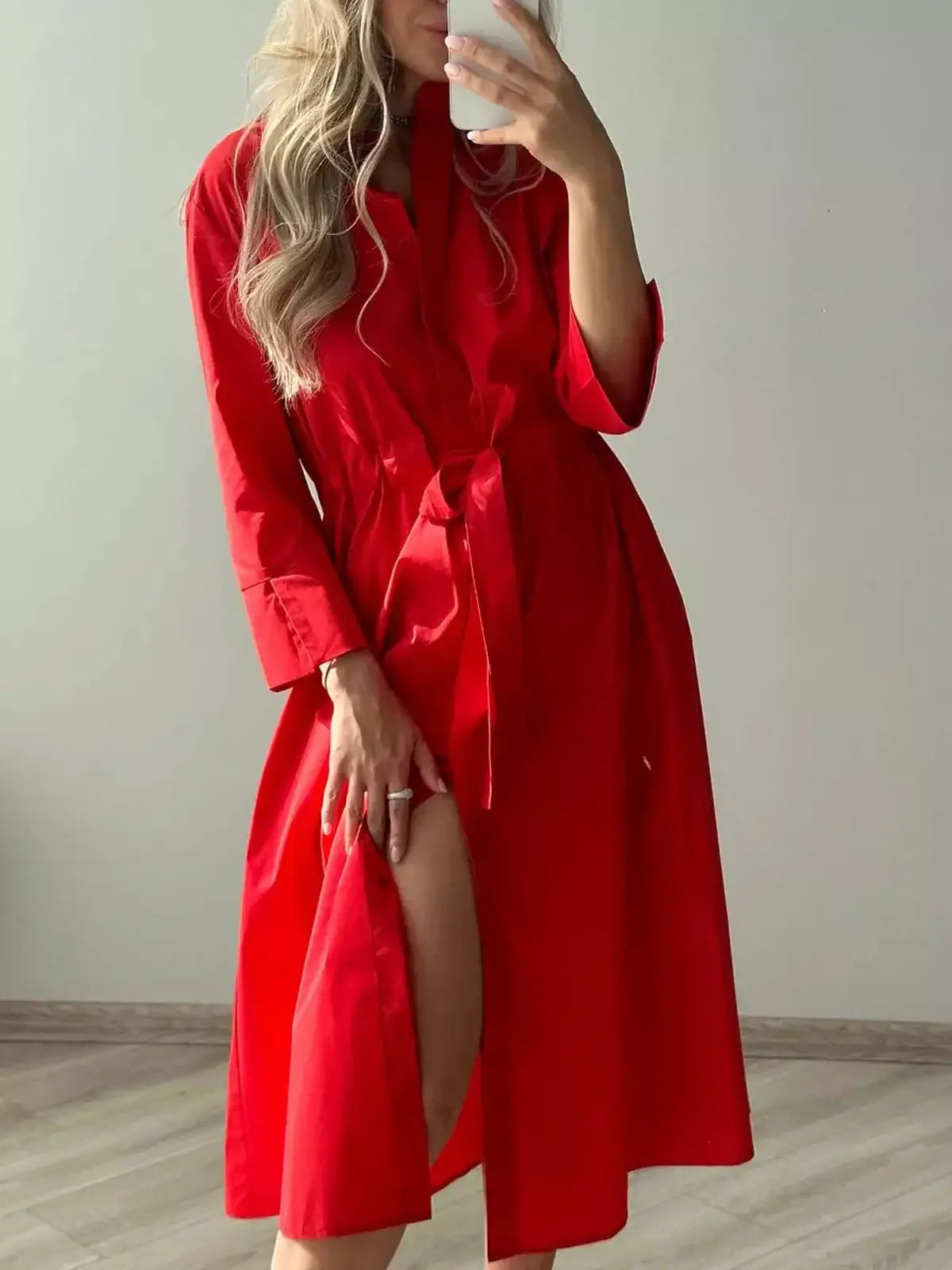 Model wearing a stylish red midi dress with a belted waist and flowing silhouette, perfect for various occasions.