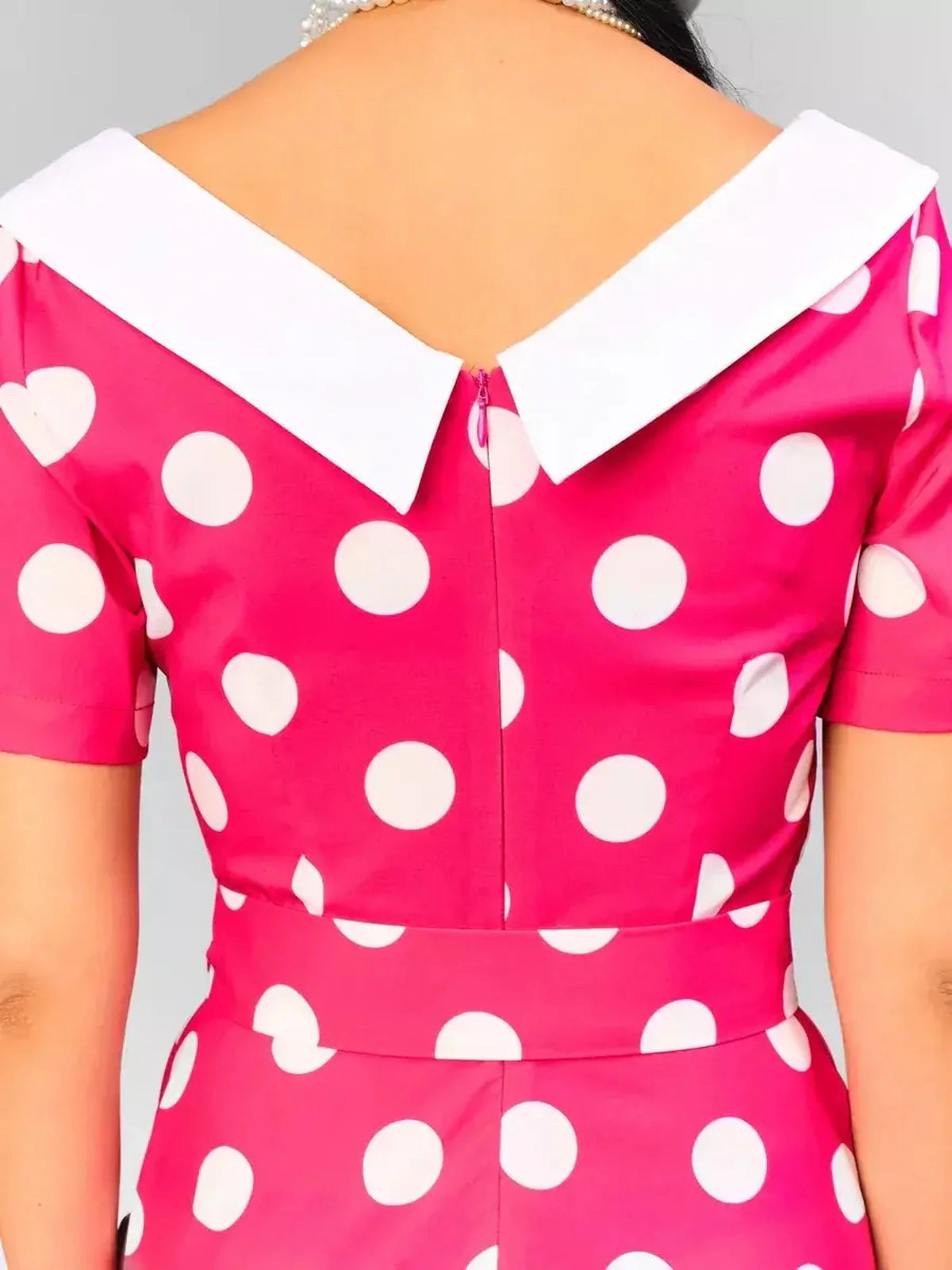 Back view of the pink polka dot midi dress featuring a white collar and stylish cut, perfect for summer events.