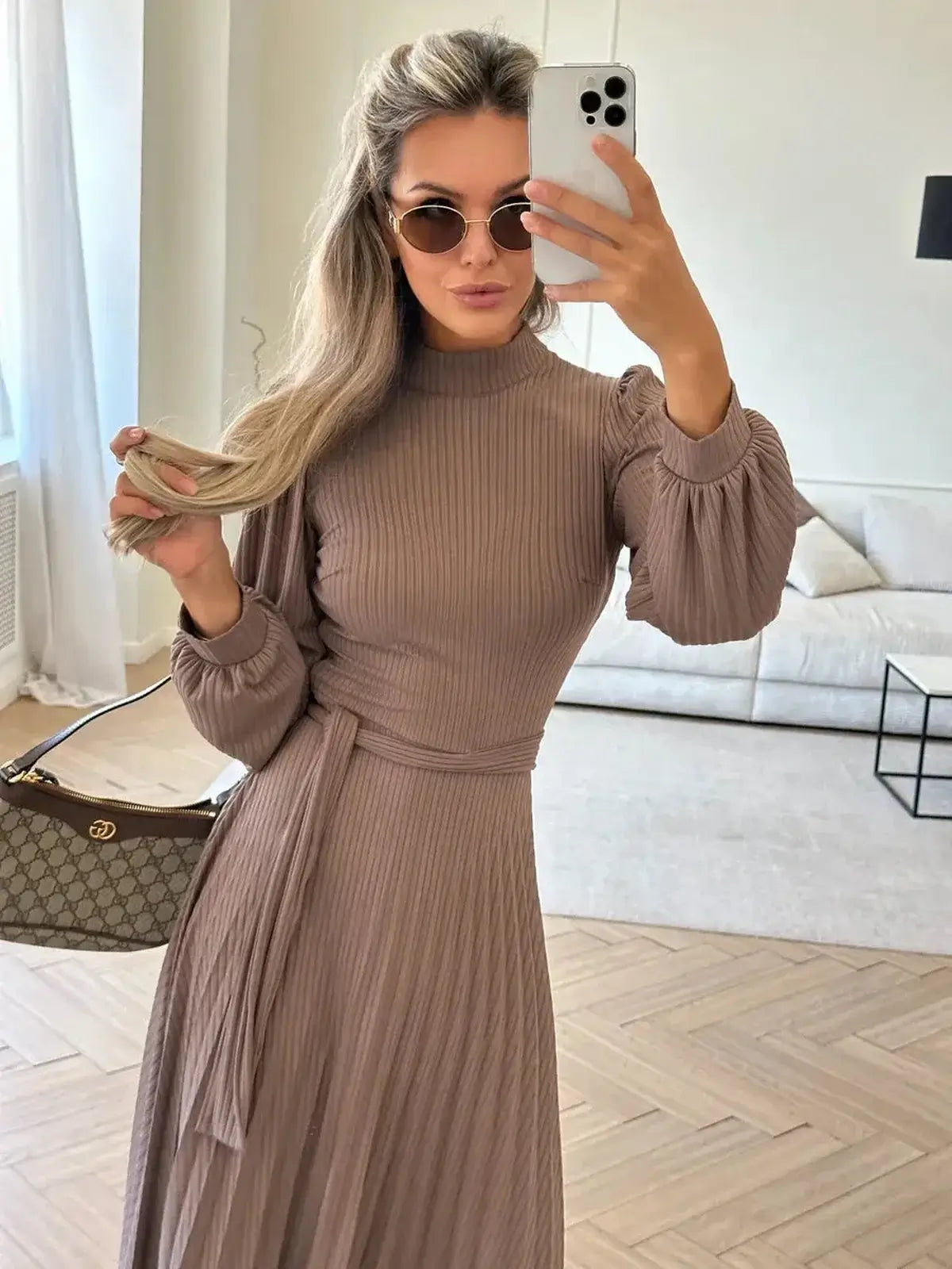 Stylish woman wearing a Plissé Charm Midi Dress in coffee hue, featuring ribbed knit texture and pleated skirt.